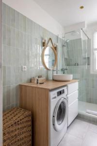 ein Badezimmer mit einer Waschmaschine und einem Spiegel in der Unterkunft PARIS 6EME - Studio in Paris