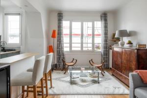 ein Wohnzimmer mit einem Glastisch und Stühlen in der Unterkunft PARIS 6EME - Studio in Paris