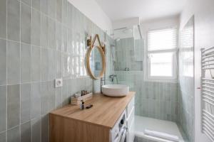 ein Bad mit einem Waschbecken und einem Spiegel in der Unterkunft PARIS 6EME - Studio in Paris