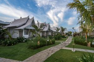 a row of white houses with a garden at Paus Putih Hotel in Nusa Lembongan