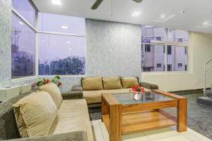 uma sala de estar com um sofá e uma mesa em Collection O 1019 Galaxy Suites em Hyderabad