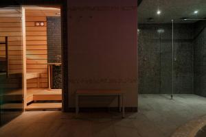 ein Bad mit einer Dusche und einer Bank in der Unterkunft Pušynė in Birštonas