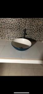 a sink in a bathroom with a stone wall at Lees' Beach House in Garita