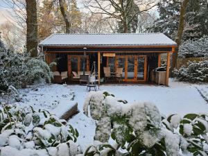 een blokhut met sneeuw op de grond bij Berghut in Doorn