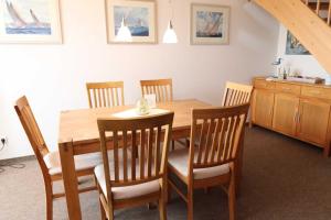uma sala de jantar com uma mesa de madeira e cadeiras em Mühlenblick - 57-03 em Kühlungsborn