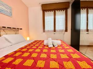 1 dormitorio con 1 cama con manta roja y amarilla en Nel Cuore della Natura - Parcheggio gratuito - Wi-Fi, en Mezzolara
