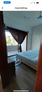 a bedroom with a bed and a window at Lees' Beach House in Garita