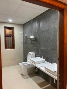 ein Badezimmer mit zwei Waschbecken, einem WC und einer Dusche in der Unterkunft Nature Korale in Galle