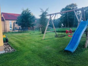 a playground with a blue slide in a yard at Haus Evi in Neusorg