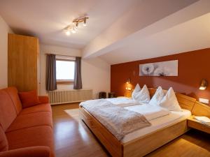 a bedroom with a large bed and a couch at Haus Hofbichl in Itter