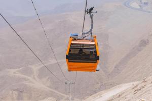 an orange cable car flying over the desert at Tolip Resort El Galala Hills in Ain Sokhna