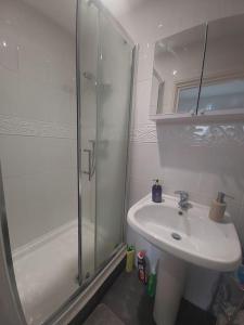 y baño blanco con lavabo y ducha. en London Zone 2, Easy Travel, en Londres
