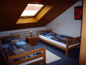 two beds in a room with a skylight at Haus Evi in Neusorg
