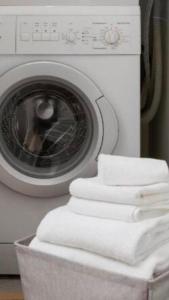 a stack of white towels next to a washing machine at 58HT Inn Centrum Apartments in Szczecin