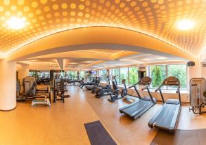 a gym with a row of treadmills and ellipticals at Grand Hotel Belvedere in Braşov