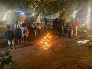 a group of people standing around a fire at Bay Walk Residency in Auroville