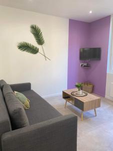 ein Wohnzimmer mit Sofa und Tisch in der Unterkunft Escapades L'Isloises au cœur de L'Isle-sur-la-Sorgue. in LʼIsle-sur-la-Sorgue