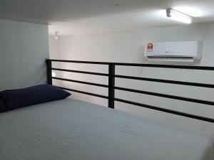 um quarto com uma cama e um corrimão com ar condicionado em Tiny House Idaman Kuala Terengganu with Private House em Kuala Terengganu