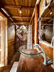 a bathroom with a glass bowl in a wooden room at Urraca Private Island Bocas del Toro in Buena Vista