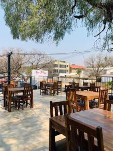 a group of wooden tables and chairs in a patio at Sirwine Hotel, Bar and Restuarant in Windhoek