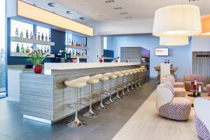 a bar in a restaurant with stools at IntercityHotel Enschede in Enschede