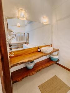 a bathroom with a wooden counter with a mirror at Pousada Vila de Pedras Noronha in Fernando de Noronha +44 photos