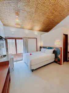 a bedroom with a bed and a television in it at Pousada Vila de Pedras Noronha in Fernando de Noronha