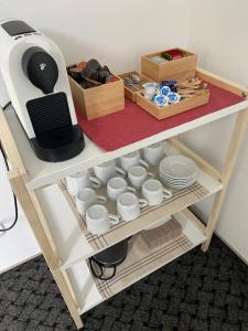 a table with cups and dishes on a shelf at W28 / Beethoven room in Piešťany
