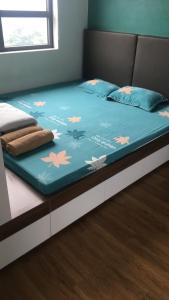 a bed with a blue comforter with flowers on it at Private homestay sea view in Halong center in Ha Long