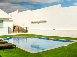 a swimming pool in the yard of a house at Big Family in La Mareta