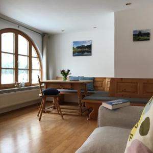 a living room with a table and a couch at Gästehaus Hotel Maria Theresia - Kennenlernpreise für den Frühling am Schliersee in Schliersee