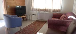 uma sala de estar com duas cadeiras e uma televisão em Refugio familiar em Pucón