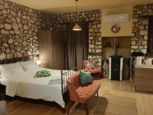 a bedroom with a bed and a chair at ΒΙΟΚΛΙΜΑΤΙΚΟ ΗΛΙΟΠΕΤΡΟΣΠΙΤΟ στην ΑΡΧΑΙΑ ΒΟΚΕΡΙΑ in Peraía