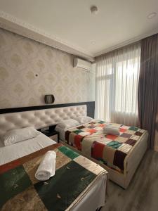 a hotel room with two beds and a window at Family Hotel Vere Tower in Tbilisi City