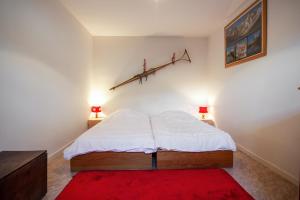 a bedroom with a bed with a red rug and two lamps at Chalet confortable à Briançon avec vue sur montagne in Briançon +12 photos