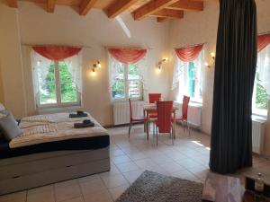 Schlafzimmer mit einem Bett, einem Tisch und Stühlen in der Unterkunft Ferienwohnung Habicht Villa-Pälitzsee in Großzerlang