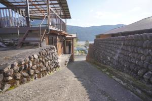 una pared de piedra junto a un edificio con escalera en 農家民宿茶の香 