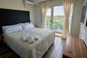 1 dormitorio con 1 cama grande y toallas. en Terrazas de Ostende - Apartamentos en Ostende