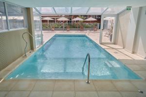 a swimming pool with blue water in a building at Terrazas de Ostende - Apartamentos in Ostende