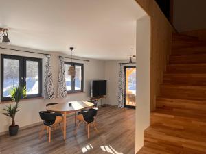 - un salon avec une table et des chaises ainsi qu'un escalier dans l'établissement Cilantro Apartments, à Szklarska Poręba