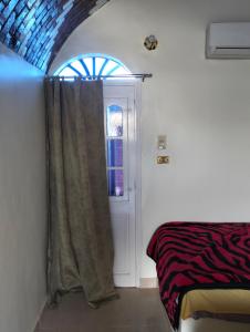a room with a window and a door with a curtain at Roma House in Aswan