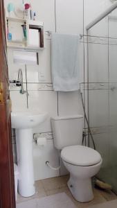 a white bathroom with a toilet and a sink at Morada do mar in Santa Cruz Cabrália