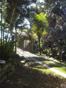 a gate in the middle of a yard with palm trees at Morada do mar in Santa Cruz Cabrália