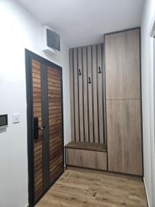a room with two wooden doors and a hallway at Hedonica 2 New Apartment in Vrdnik
