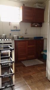 a kitchen with wooden cabinets and a stove top oven at Morada do mar in Santa Cruz Cabrália