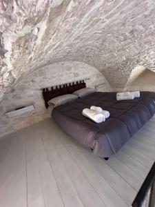 a room with a bed in a stone wall at LA 13 guest house in Ostuni