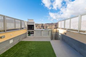a balcony with a green lawn on a building at Luxury House - Puerto Rico in Puerto Rico de Gran Canaria
