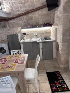 une petite cuisine avec une table et un évier dans l'établissement LA 13 guest house, à Ostuni 23 autres photos
