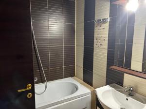 a bathroom with a bath tub and a sink at Apartament Summerland Mamaia Nord in Mamaia