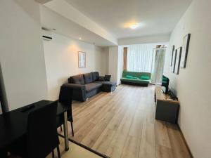 a living room with a couch and a table at Apartament Summerland Mamaia Nord in Mamaia